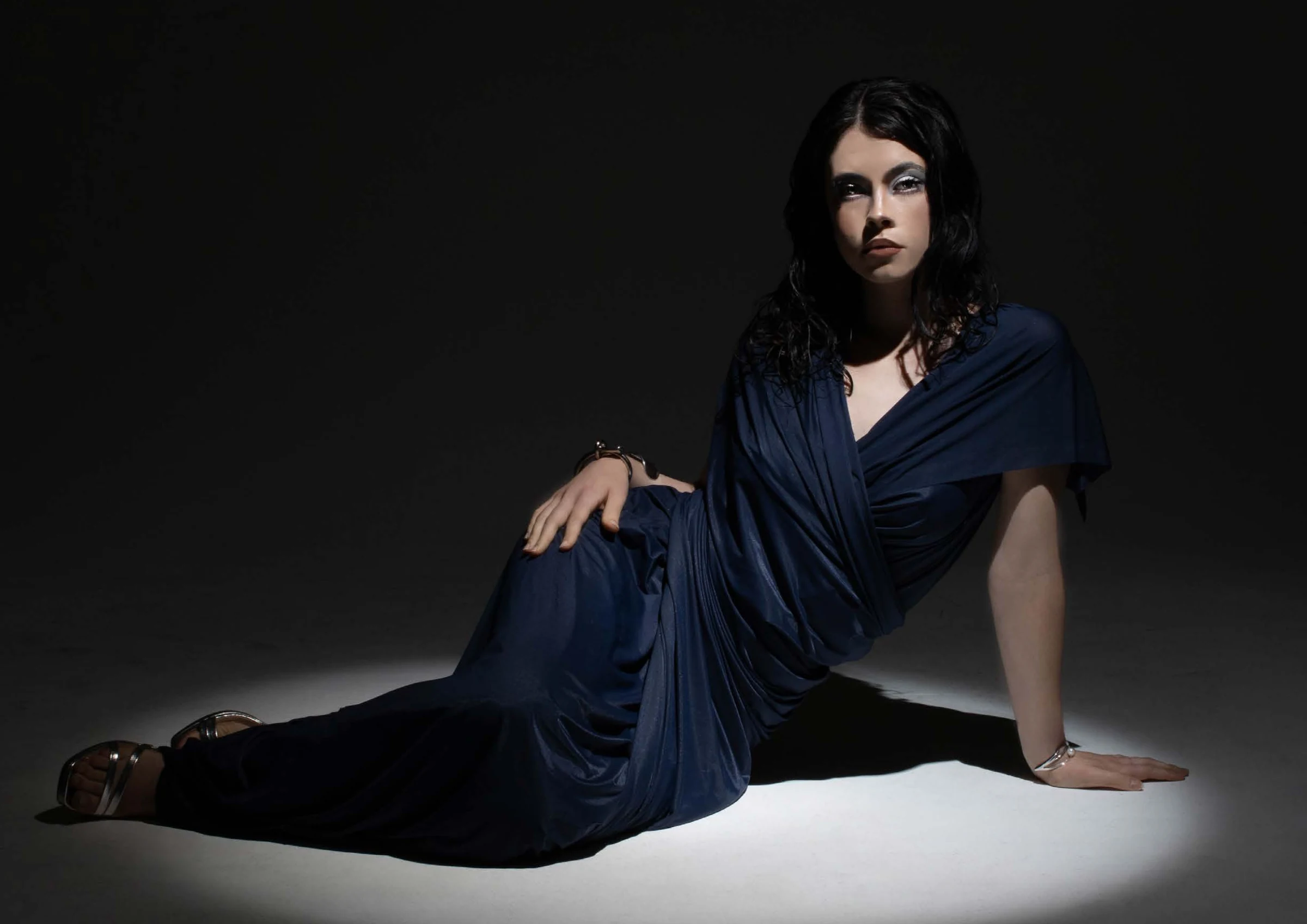 Reclining model in a midnight-blue dress