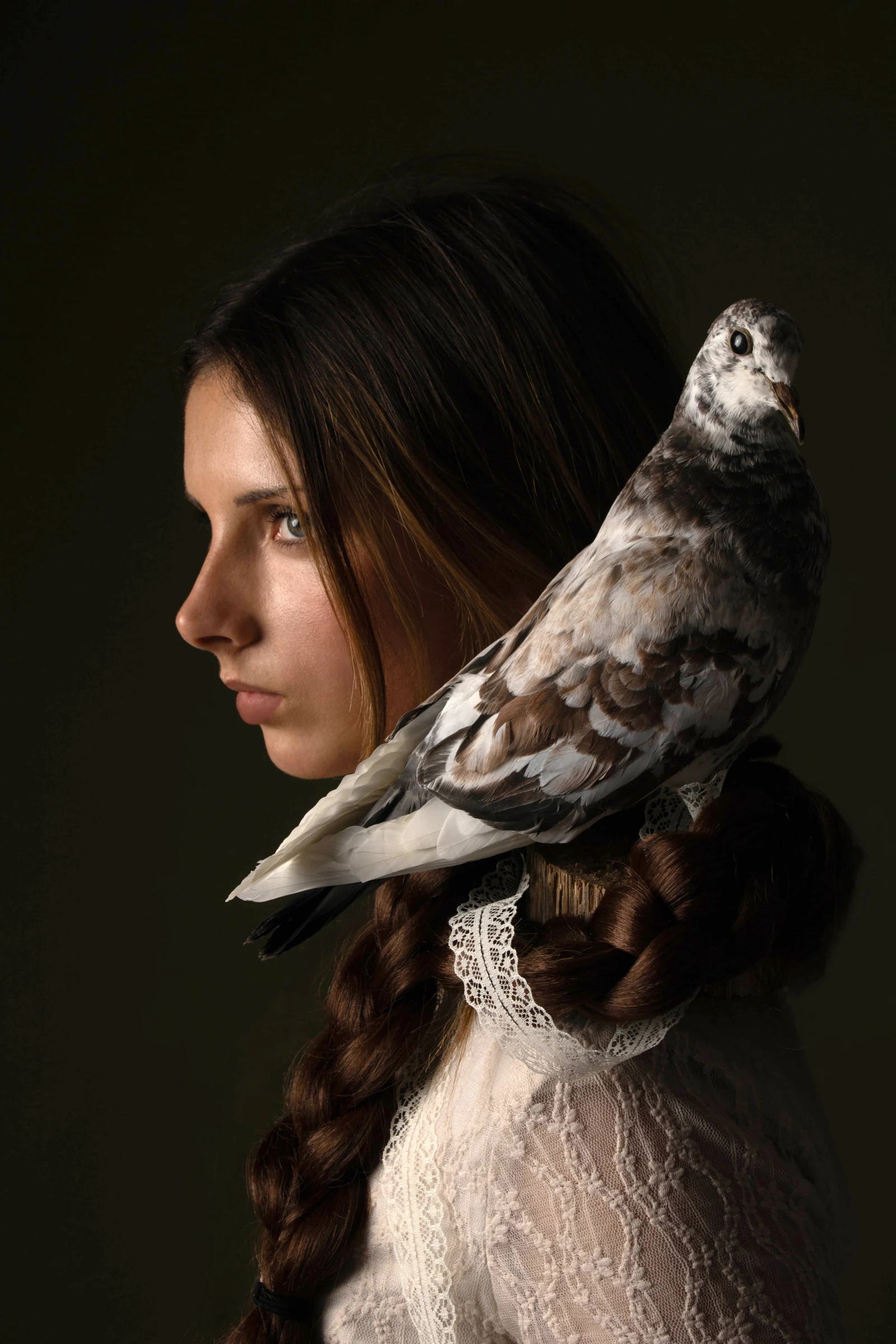 Model in profile holding a bird for Vigil