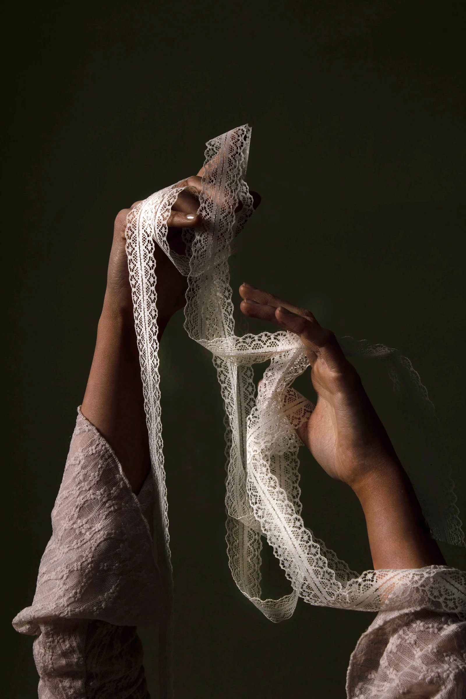 Close-up of gloved hands holding a sculptural object