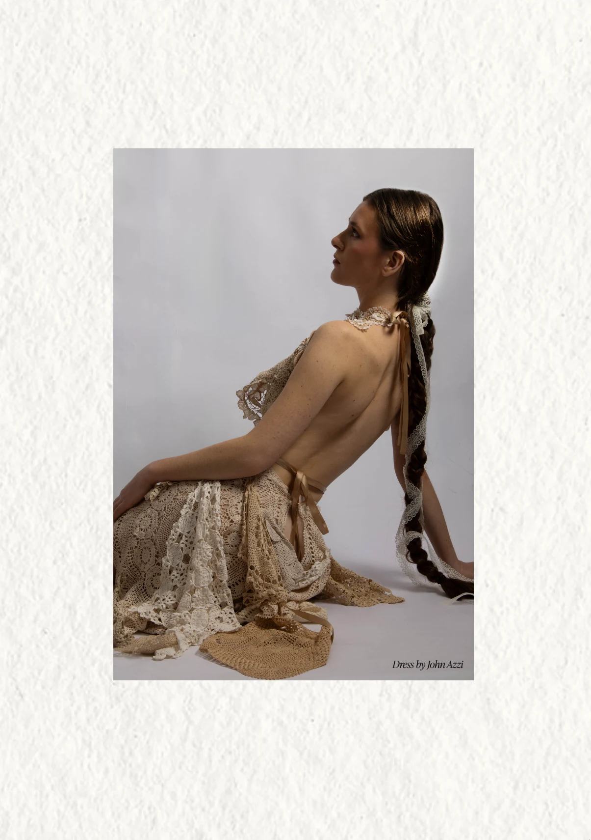 Seated model presented within a textured white page